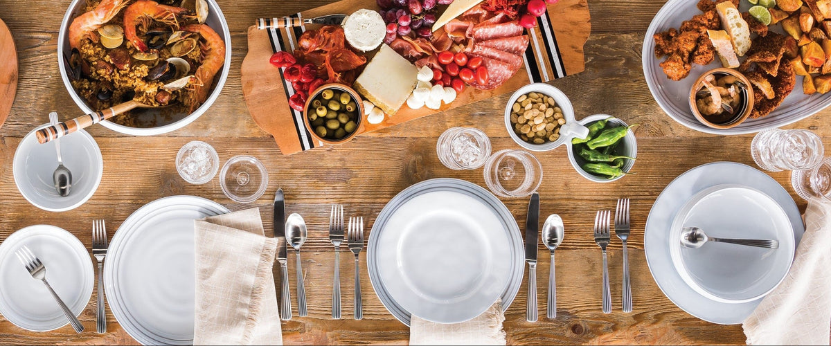 A beautifully arranged table with various dishes including seafood, charcuterie, and vegetables