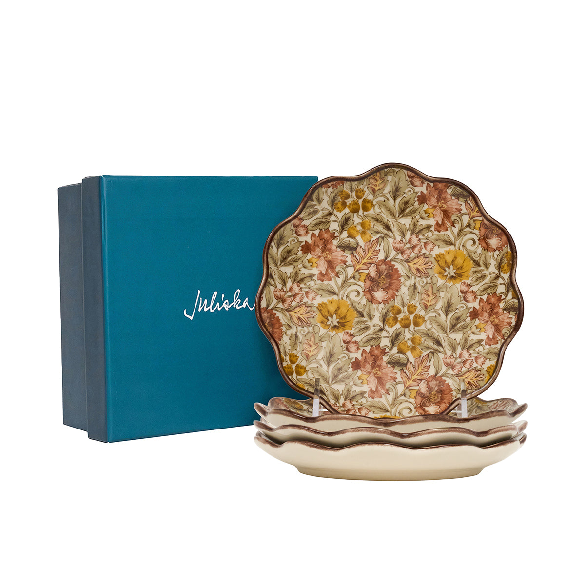 Decorative ceramic plates with floral design in front of a blue Juliska box.