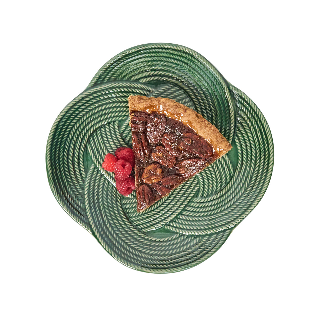 Slice of pecan pie with raspberries on a green patterned plate