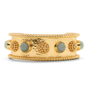 Gold bracelet with textured design and green stones on a white background