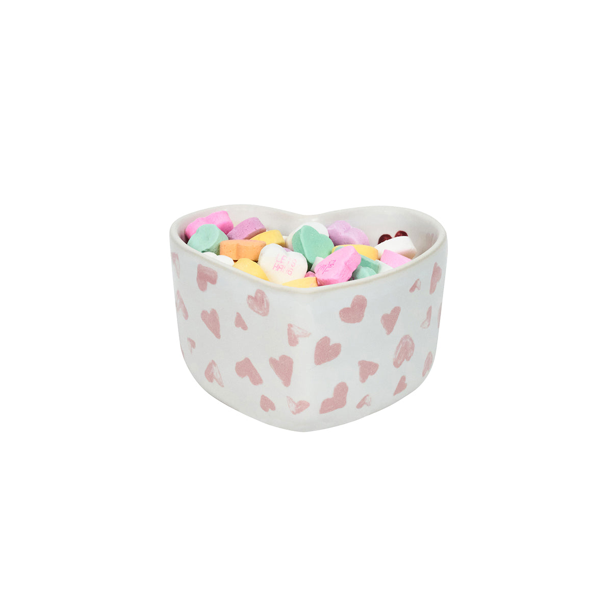 Heart-shaped bowl with pink heart pattern filled with colorful candies on a white background