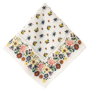 A square white cotton napkin with a delicate all-over floral print and a wide decorative border, shown on a plain white background.
