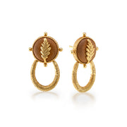Pair of gold earrings with brown stones and leaf designs on a white background