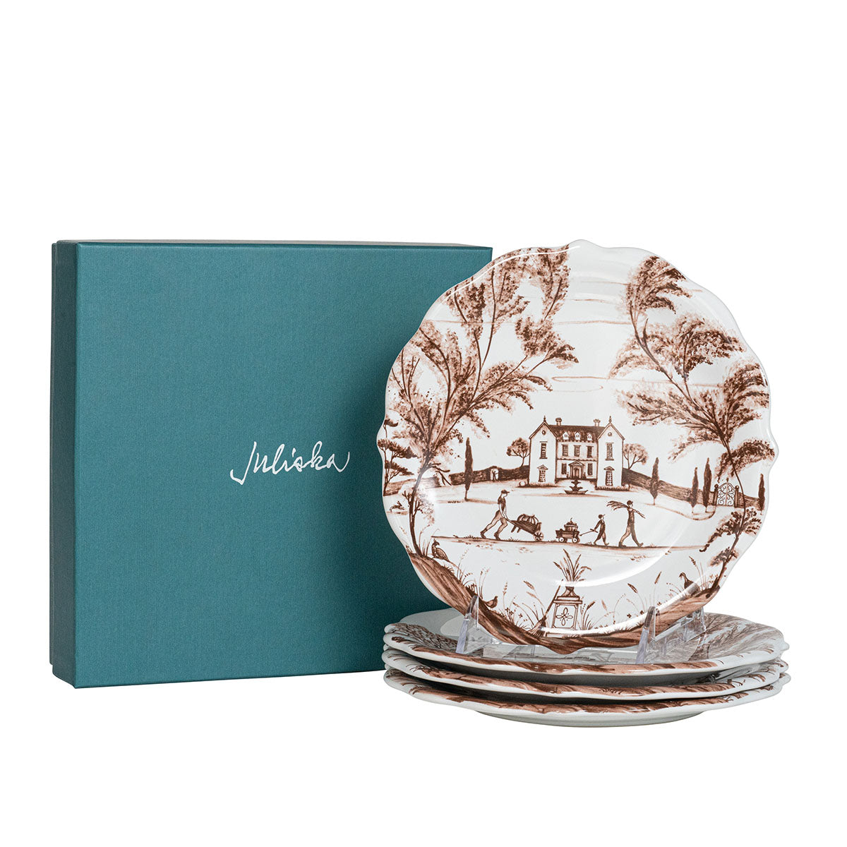 Set of decorative plates with a pattern in front of a teal box with 'Juliska' branding.