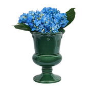 Green vase with blue flowers on a white background