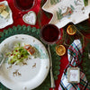 Decorative Christmas table setting with plaid tablecloths, plates, and tree-shaped centerpieces.