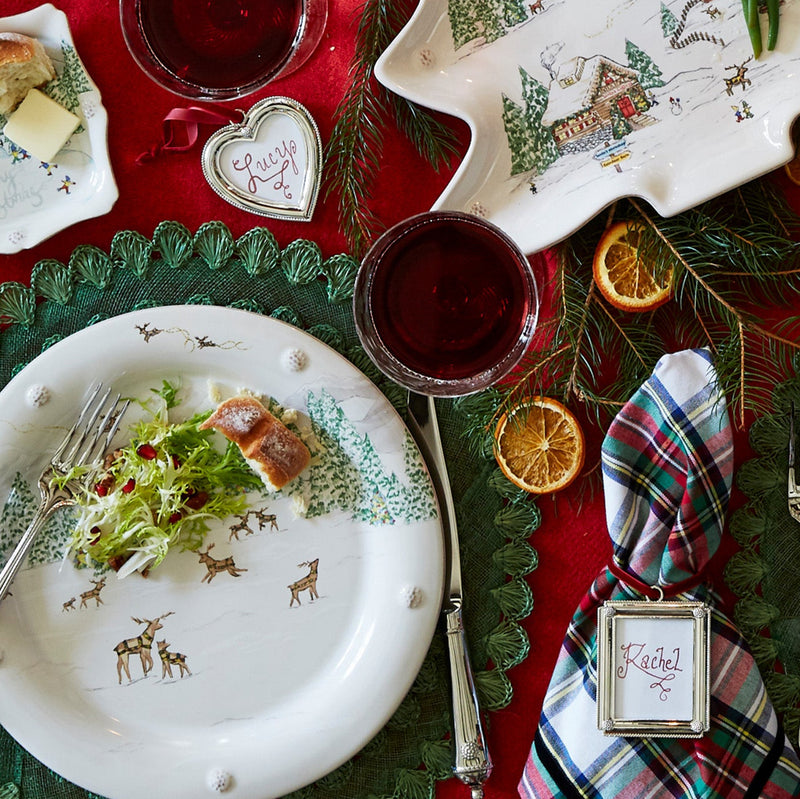 Decorative Christmas table setting with plaid tablecloths, plates, and tree-shaped centerpieces.