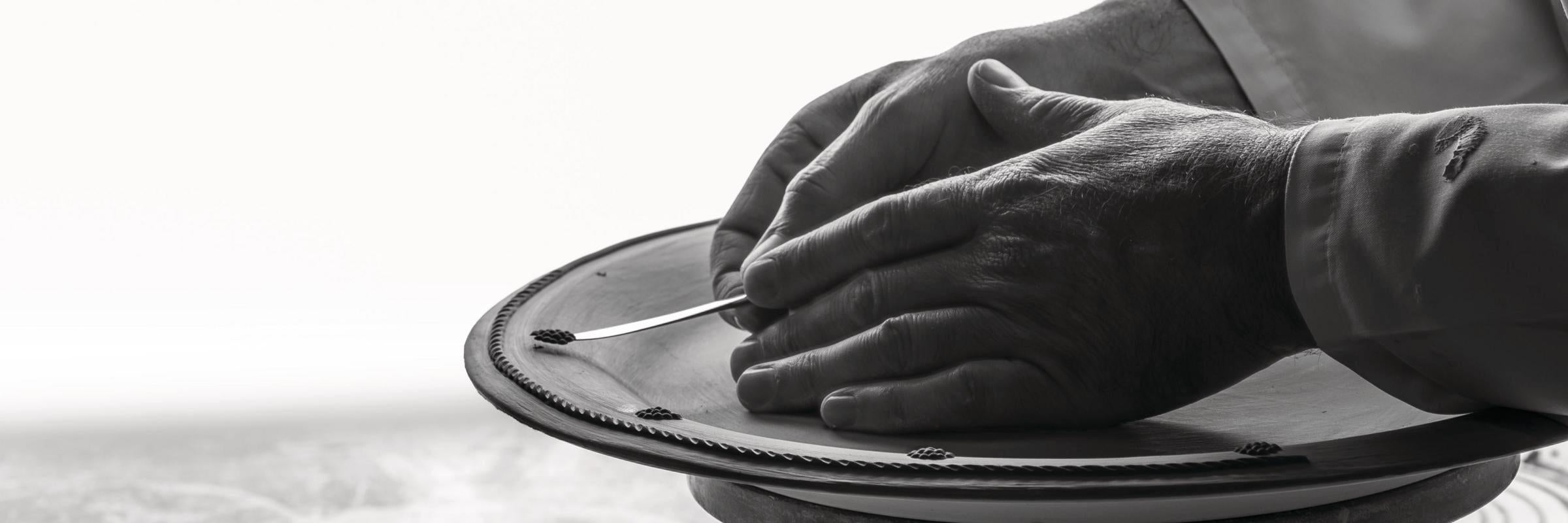 Person holding a metallic object with a blurred background