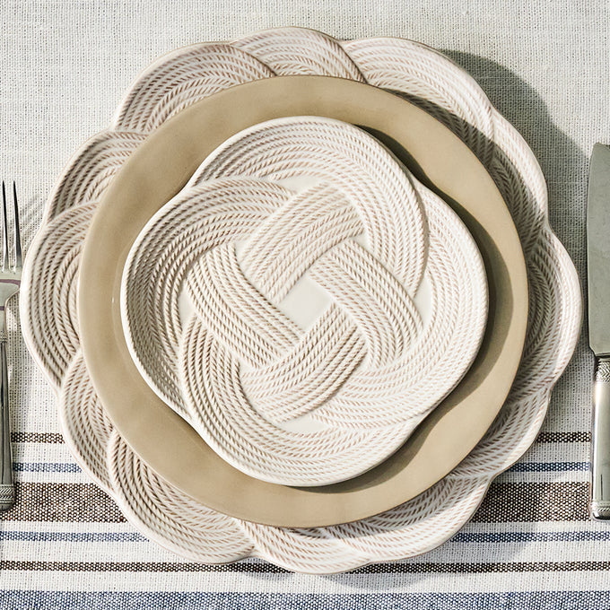 Rope-wrapped plates on a striped tablecloth with cutlery