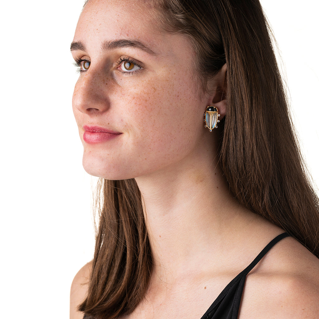 Woman wearing a gold earring on a white background