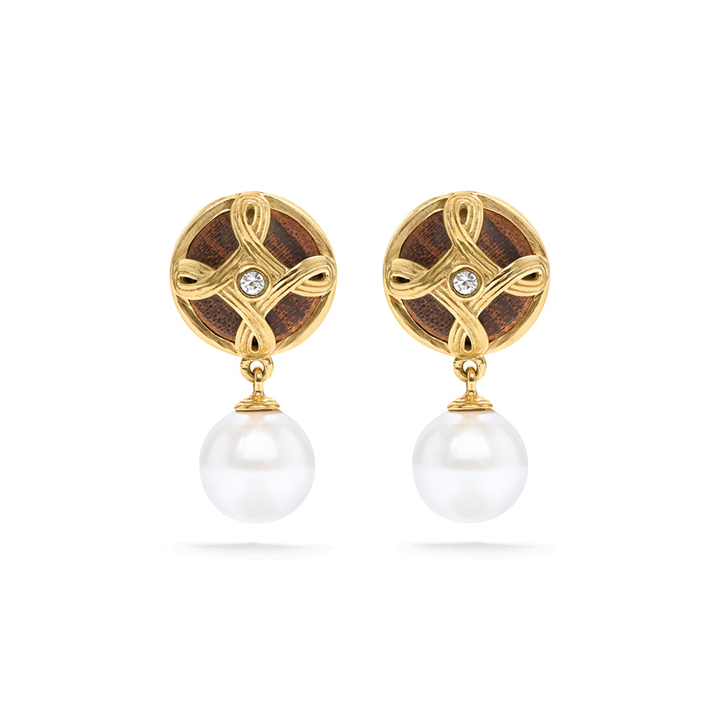 A pair of gold and brown drop earrings with a circular knotwork design, a small clear stone in the center, and a dangling white pearl below, shown on a white background.