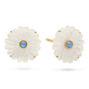 A pair of daisy-shaped stud earrings featuring white mother-of-pearl petals, gold-tone metal borders, and a central round light blue gemstone, shown on a clean white background.