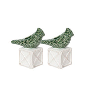 Two green ceramic birds on white geometric bases against a white background