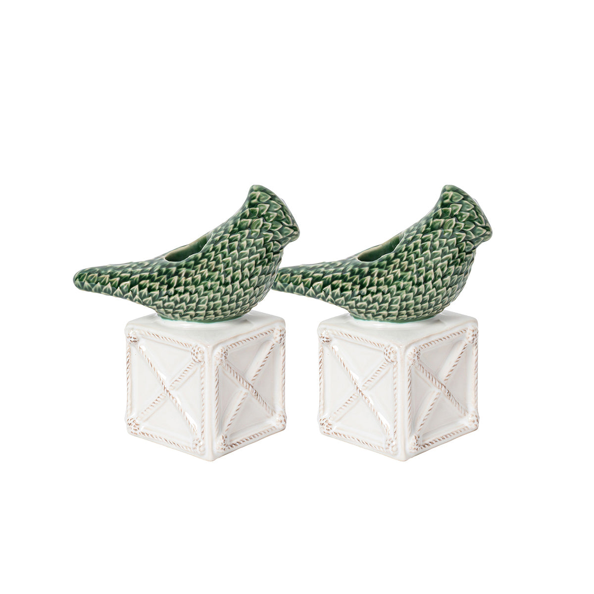 Two green ceramic birds on white geometric bases against a white background