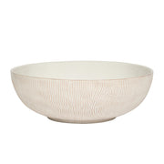 Beige ceramic bowl with textured surface on a white background