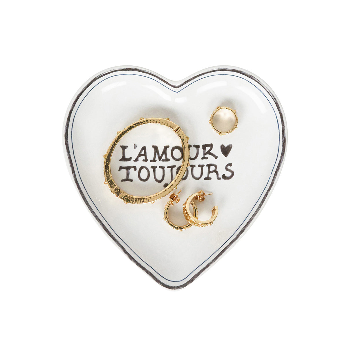 Heart-shaped jewelry dish with gold rings and 'L'Amour Toujours' text on a white background