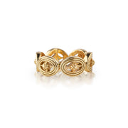 A gold ring with three interlocking oval motifs and small floral details, photographed on a clean white background.