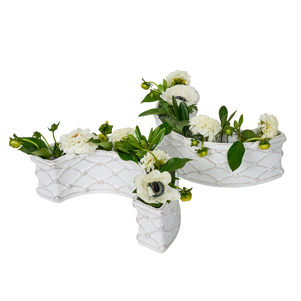 Decorative white flower pots with greenery on a white background