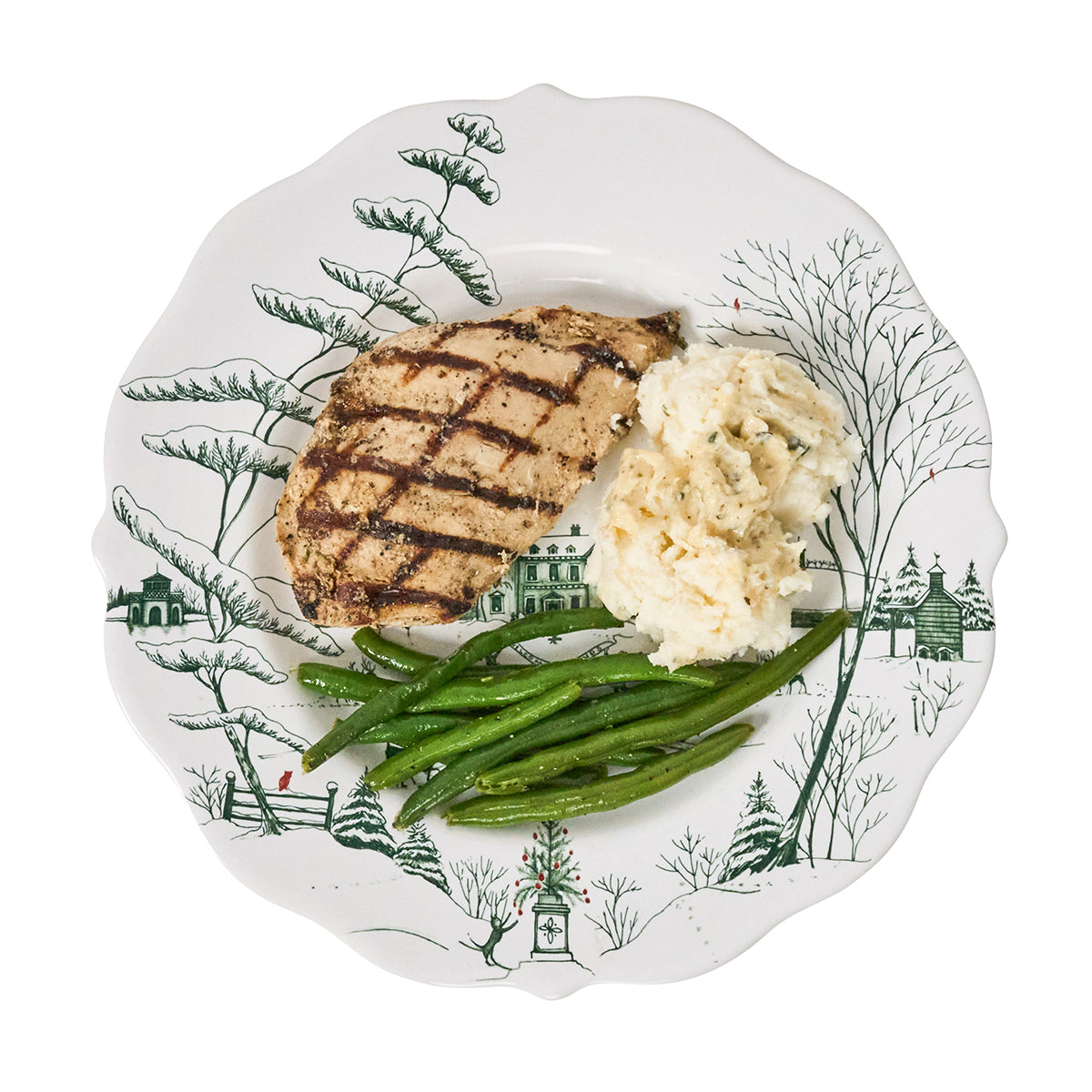 Grilled chicken, mashed potatoes, and green beans on a decorative plate with a winter scene design.