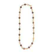 A long beaded necklace featuring alternating round brown beads and textured gold oval links, displayed on a clean white background.