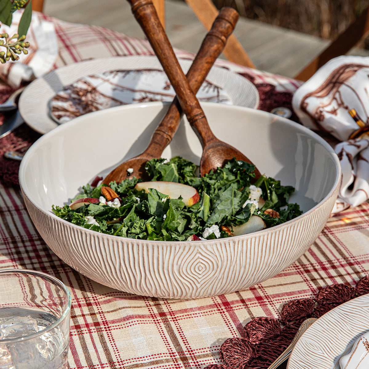 White bowl with a green salad on a checkered tablecloth