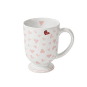 White mug with pink heart pattern on a white background