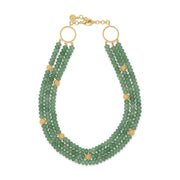 A three-strand beaded necklace featuring light green faceted beads and gold-tone metal accents, including circular ring connectors, small spacer beads, and a chain clasp, shown on a plain white background.